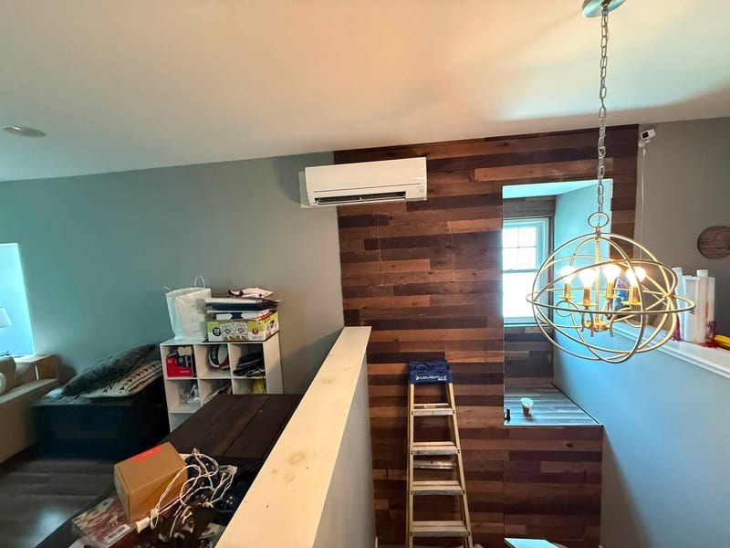 Ductless wall unit mounted high in a room under renovation