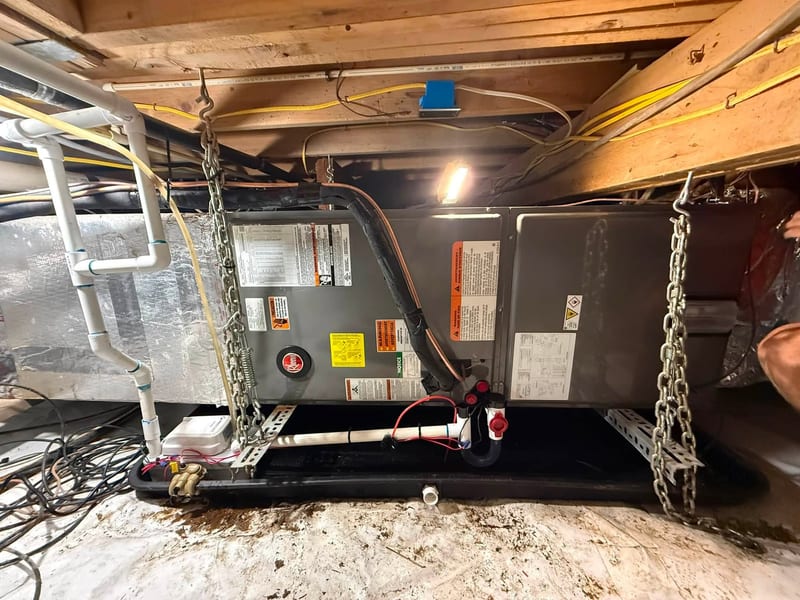 Air handler hung on chains in a crawlspace during a service visit